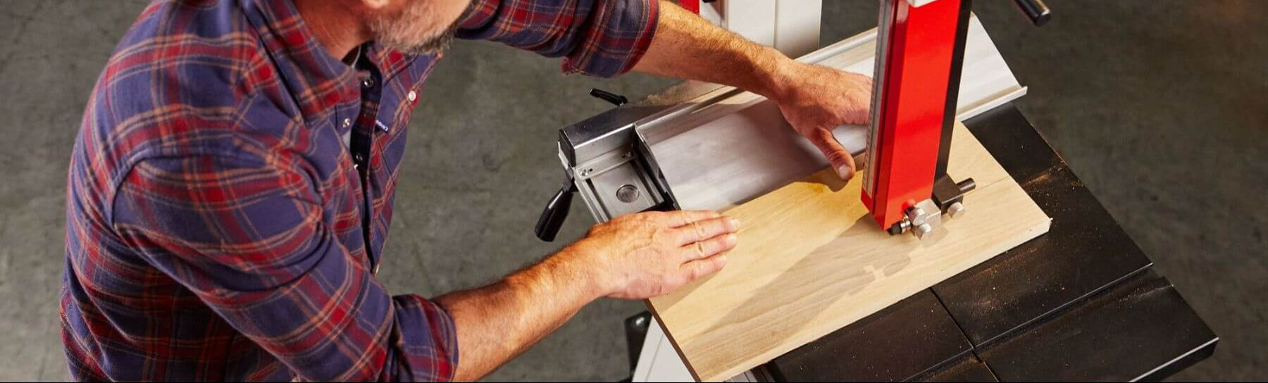 Man operating a band saw in a workshop setting